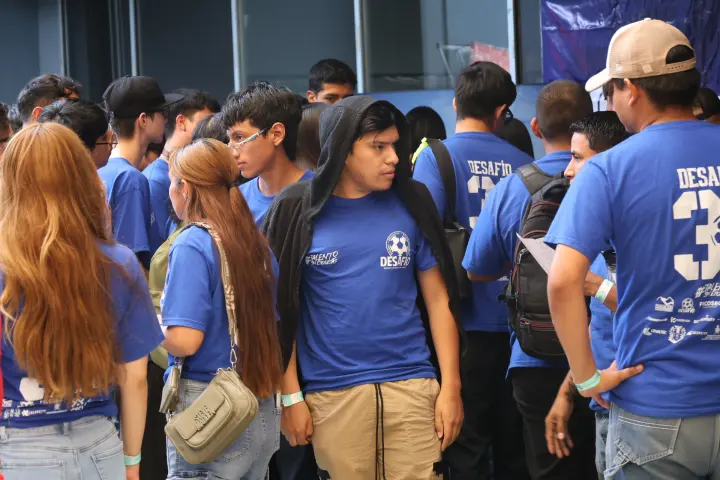 Jóvenes con playeras azules de Desafío reunidos en un evento