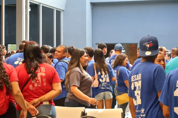 Jóvenes con playeras azules y rojas de Desafío en un evento