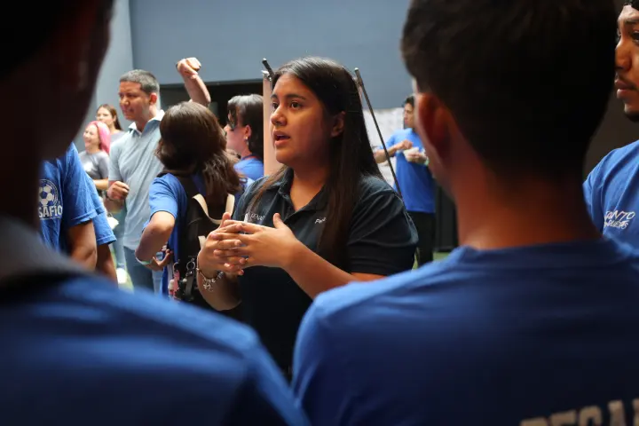 Una joven conversa con otros asistentes durante un evento
