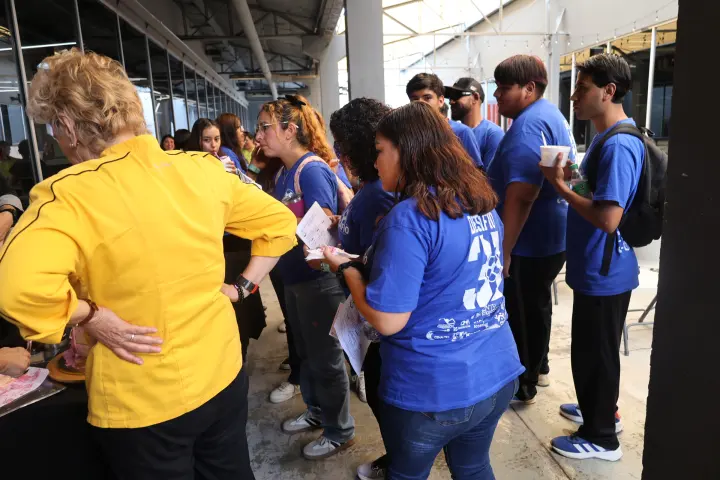 Una facilitadora de amarillo conversa con jóvenes