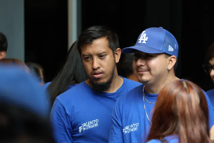 Dos jóvenes con playera de Desafío conversan