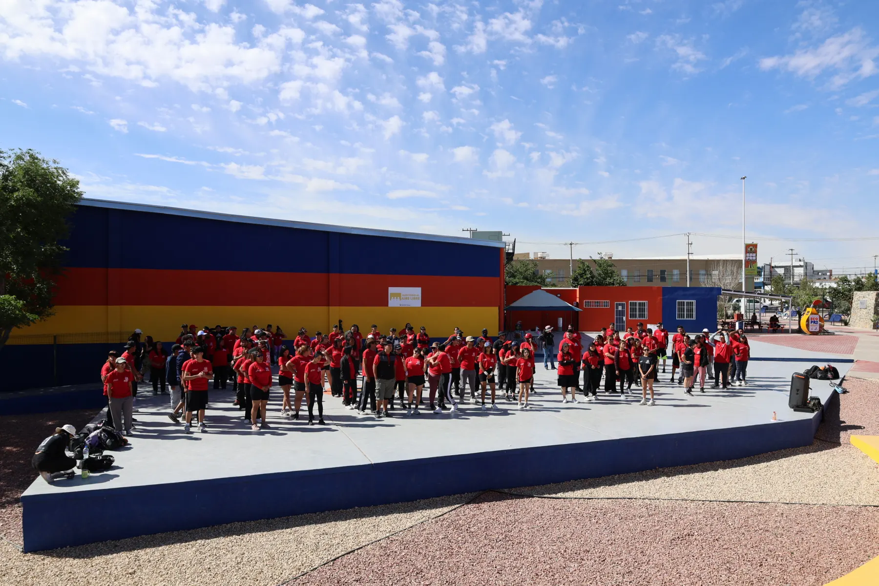Grupo de jóvenes de rojo reunido en una cancha techada