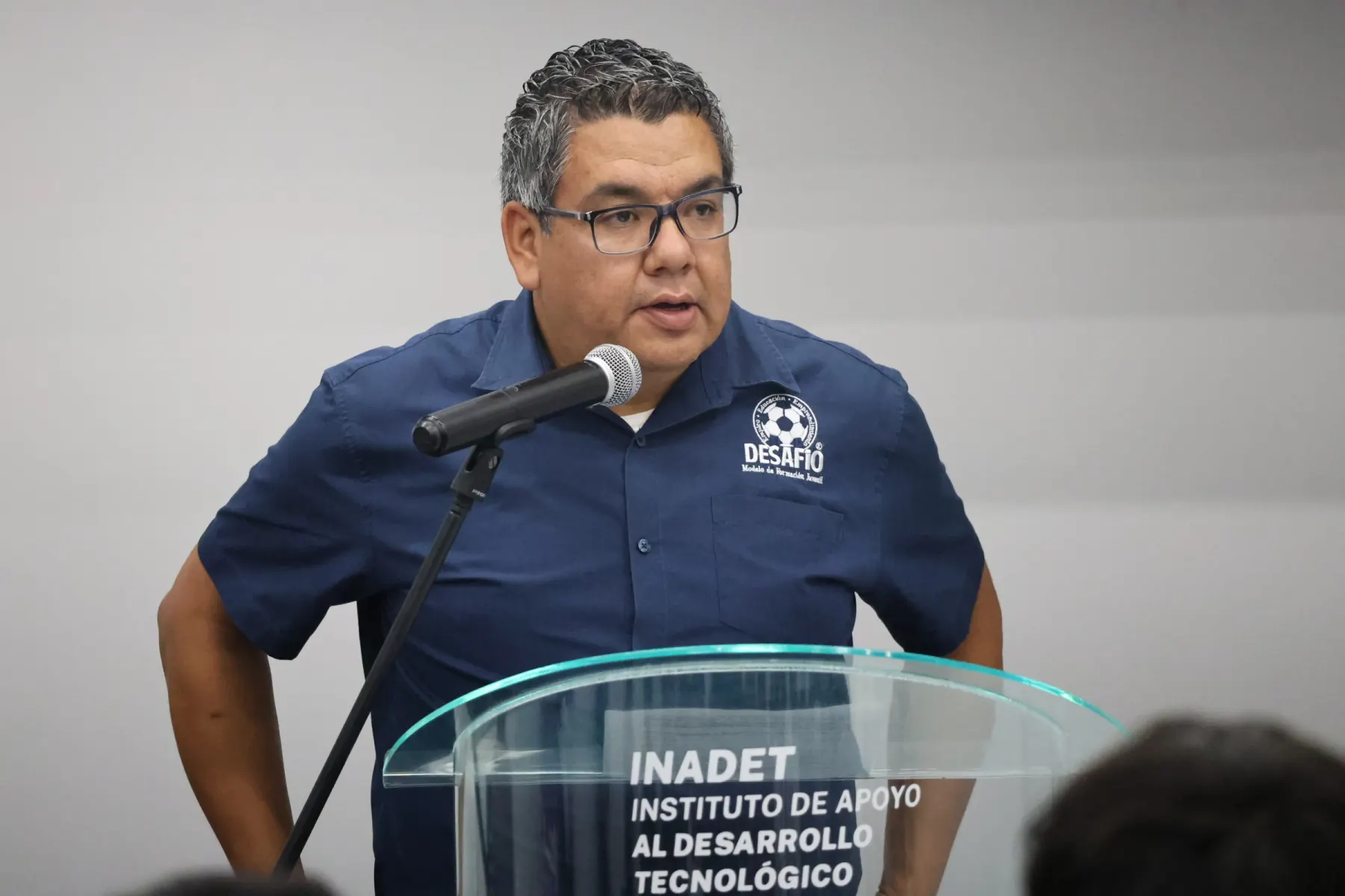 Un funcionario habla desde el podio durante un evento de Desafío
