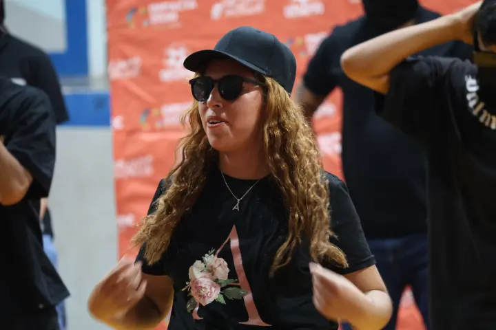 Una joven con lentes oscuros frente al fondo de Desafío