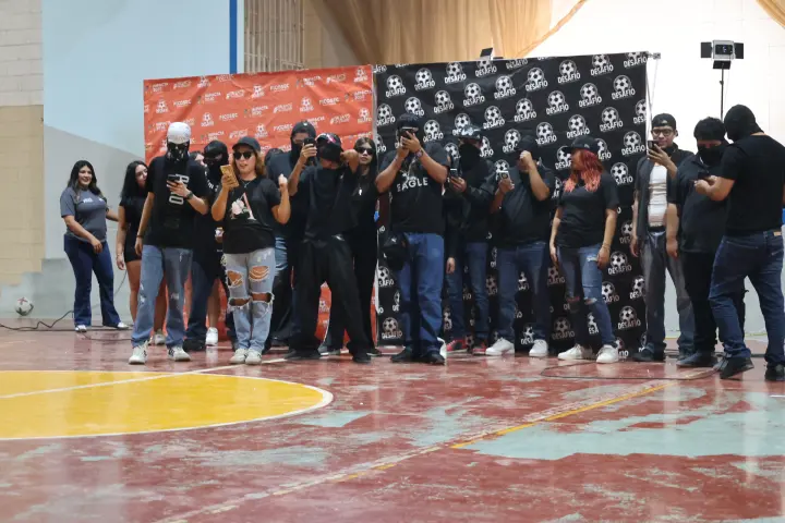 Facilitadores vestidos de negro en una cancha techada