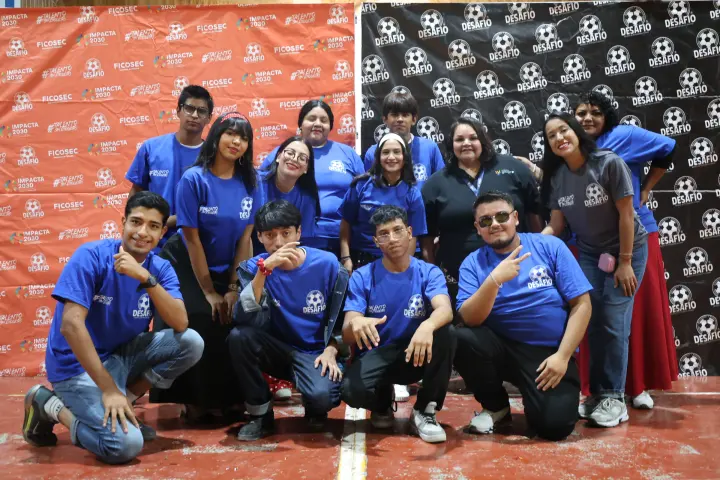 Jóvenes posan con playeras azules de Desafío
