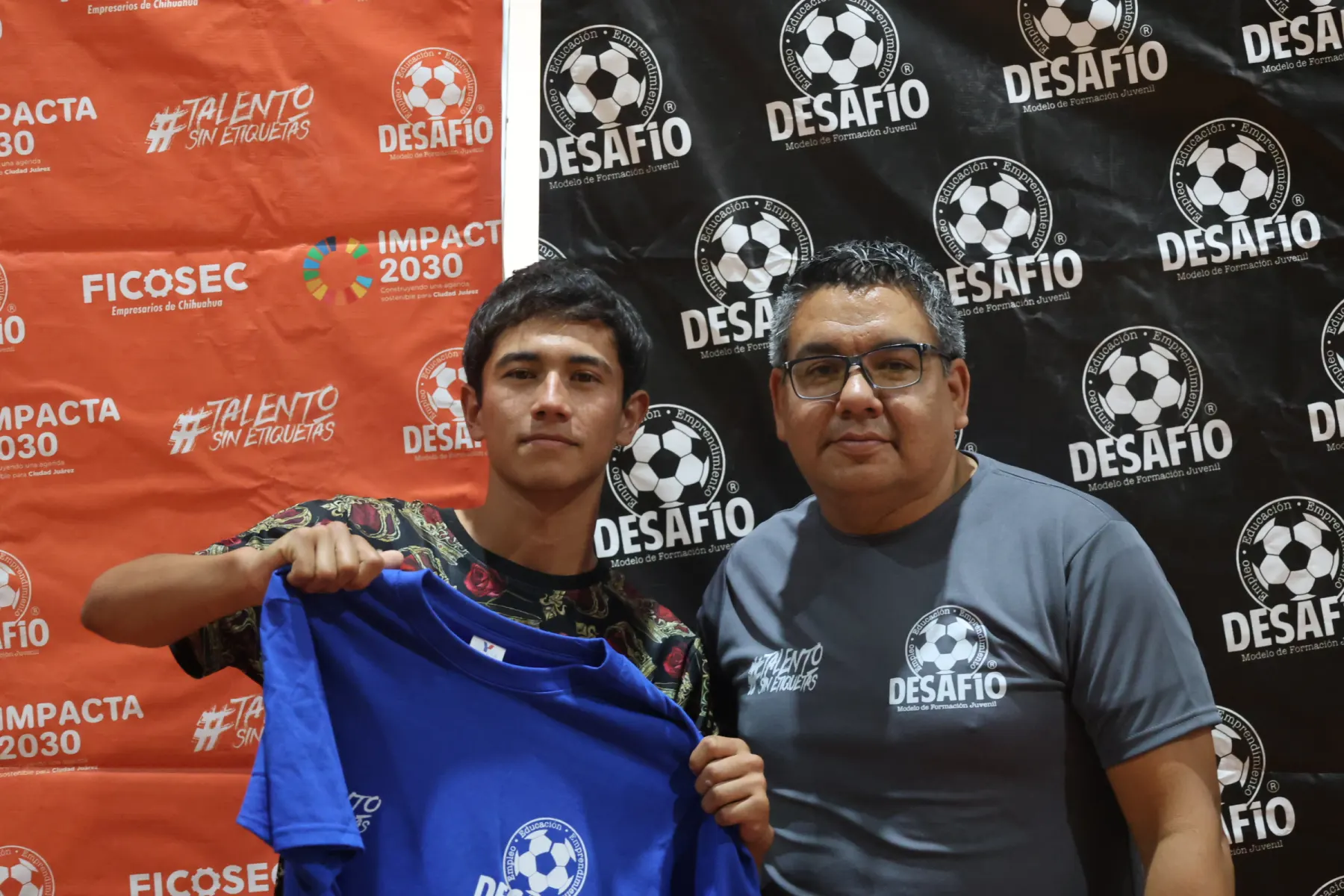 Una pareja sostiene la playera azul de Desafío