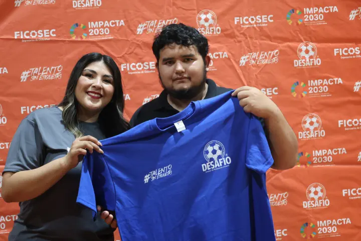 Un joven y una mujer sostienen la playera de Desafío