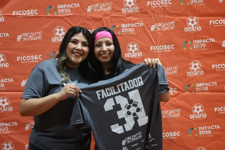 Dos mujeres muestran una playera de facilitador