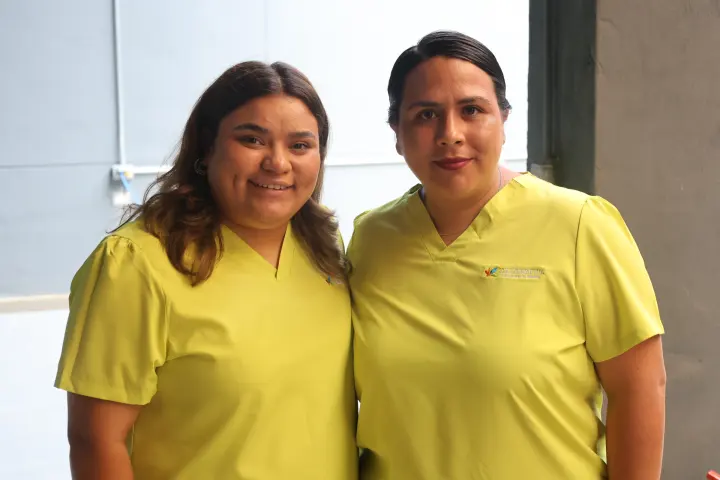 Dos mujeres de amarillo sonríen a la cámara
